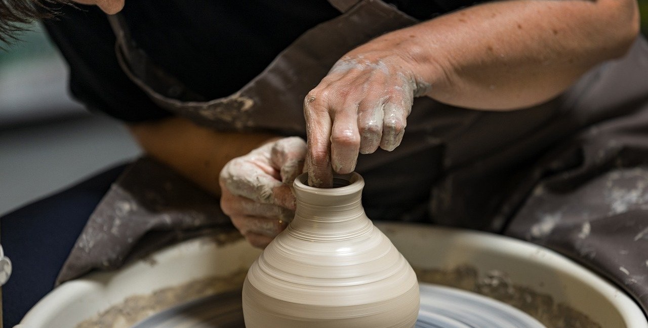 a person making pottery on a wheel