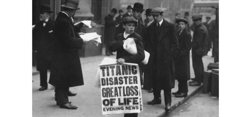 newsboy holds paper with the headline, Titanic disaster great loss of life