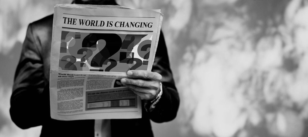 a man is reading a newspaper that says The World Is Changing