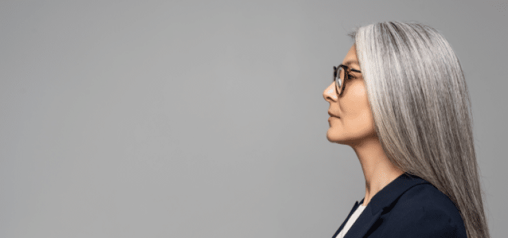 profile of an attractive gray-haired woman in glasses