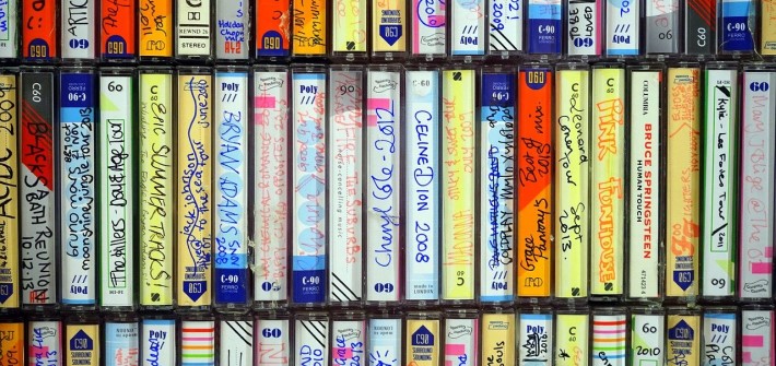 A wall of homemade mixed tapes with hand written label designs