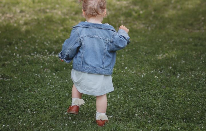 toddler girl in blue dress running on grass