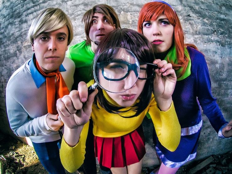 A Scooby Doo cosplay group. Velma character looks through magnifying glass