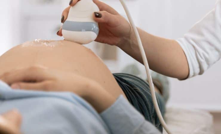 pregnant woman lying on her back while an ultrasound is being performed